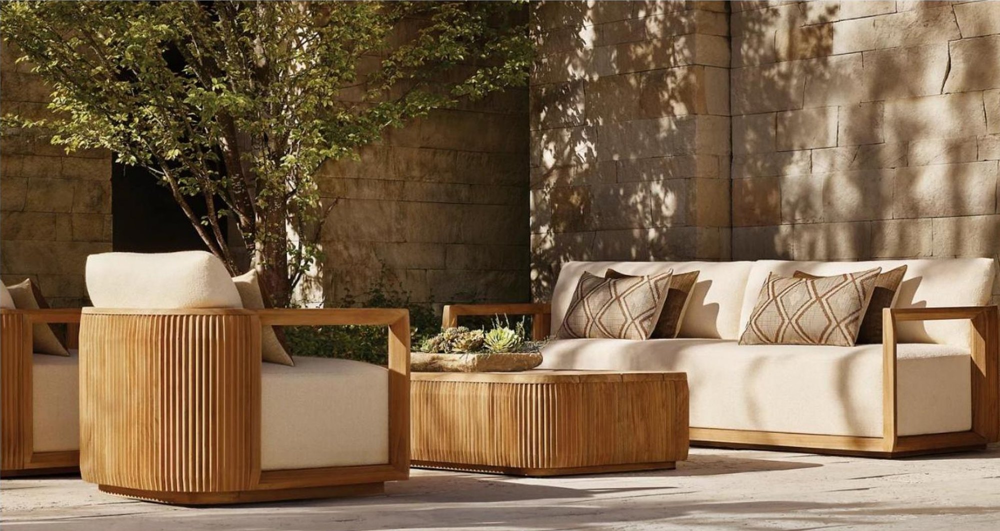SLY fluted teak sofa and armchairs on a stone terrace
