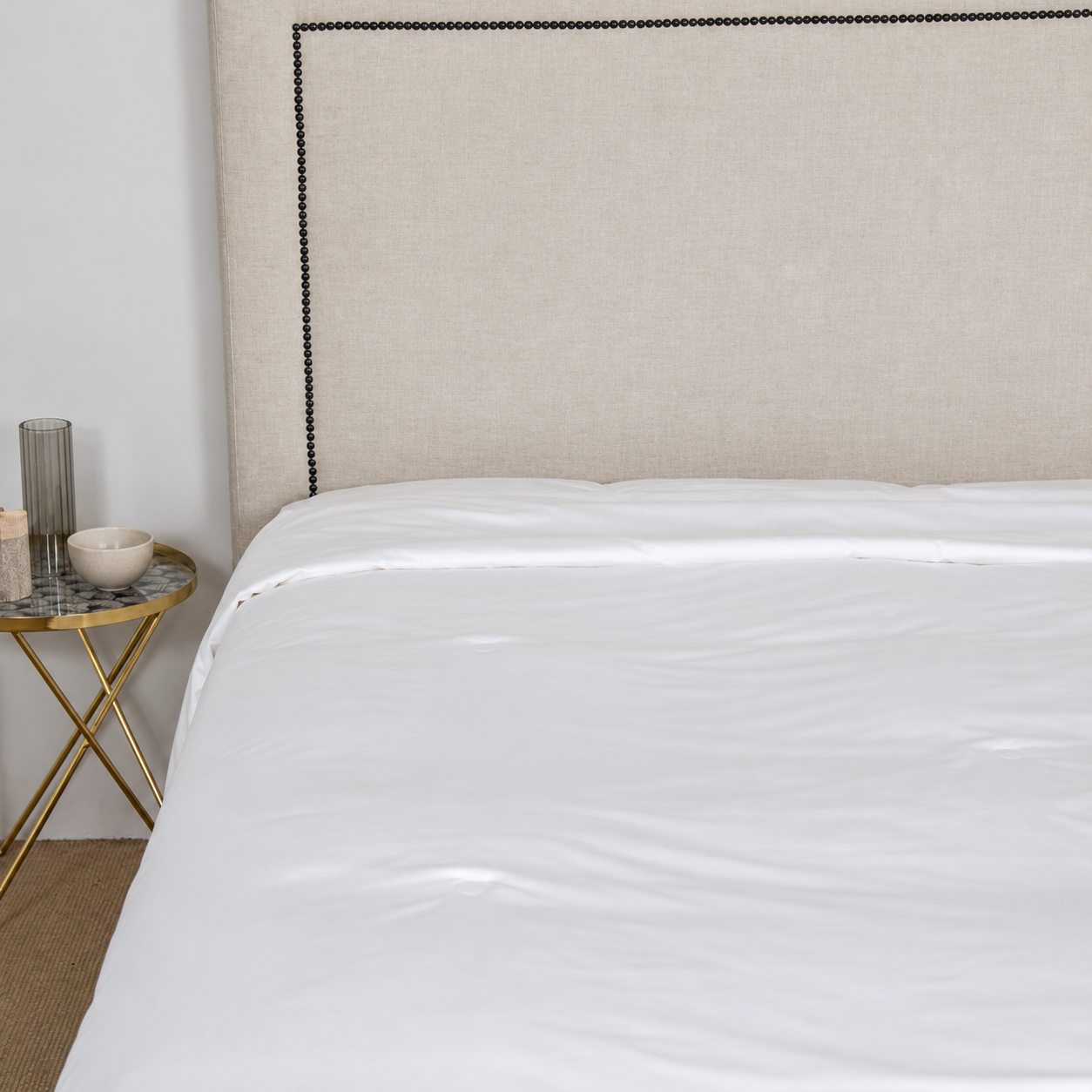 Slim white silk duvet insert draped across a bed